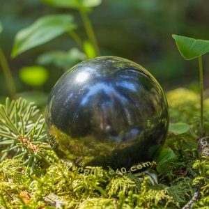 black sphere shungite on a stand polished surface
