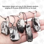 several pendants made of the rare mineral type I shungite in hand