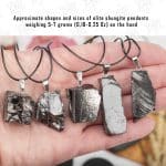 several middle pendants made of the rare mineral type I shungite in hand